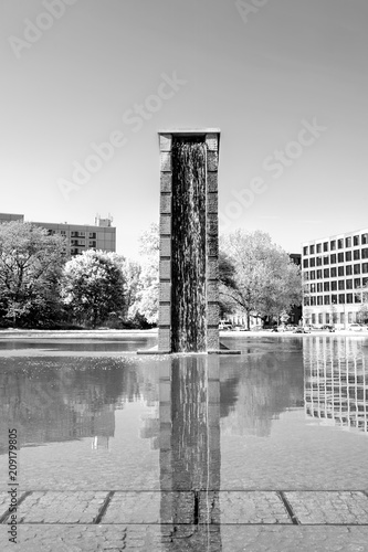 Modern architecture fountain, in infrared black and white, surrounded by water, in downtown Berlin