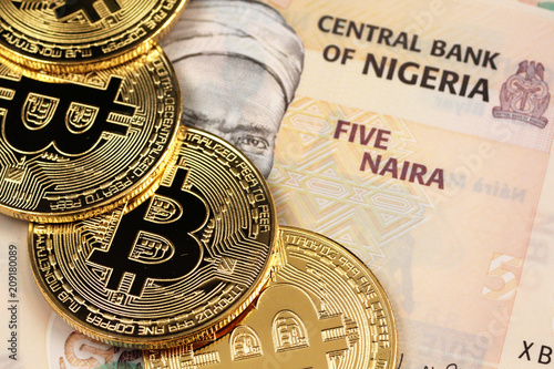 A close up image of Nigerian 5 Naira bank notes with gold bitcoins