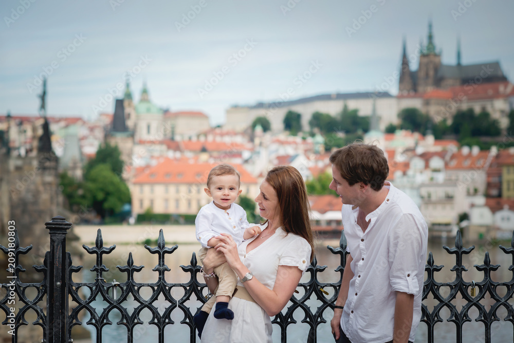 Fototapeta premium Młoda rodzina z małym chłopcem odwiedza Pragę
