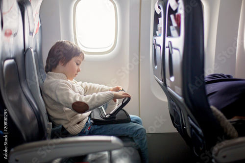 Cute six years old boy, playing on tablen in aircraft on board photo