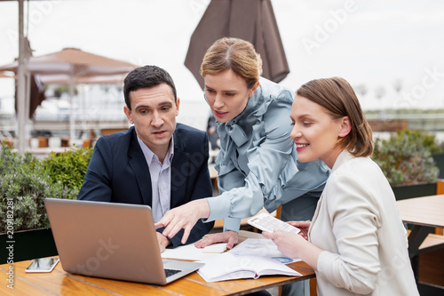 Meeting outside. Three successful financial directors feeling occupied while having important monthly staff meeting outside