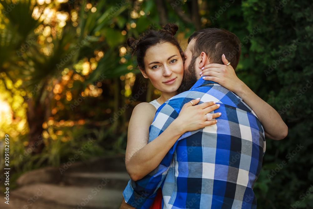 Portrait of a happy couple hugging in the street with the woman face in foreground