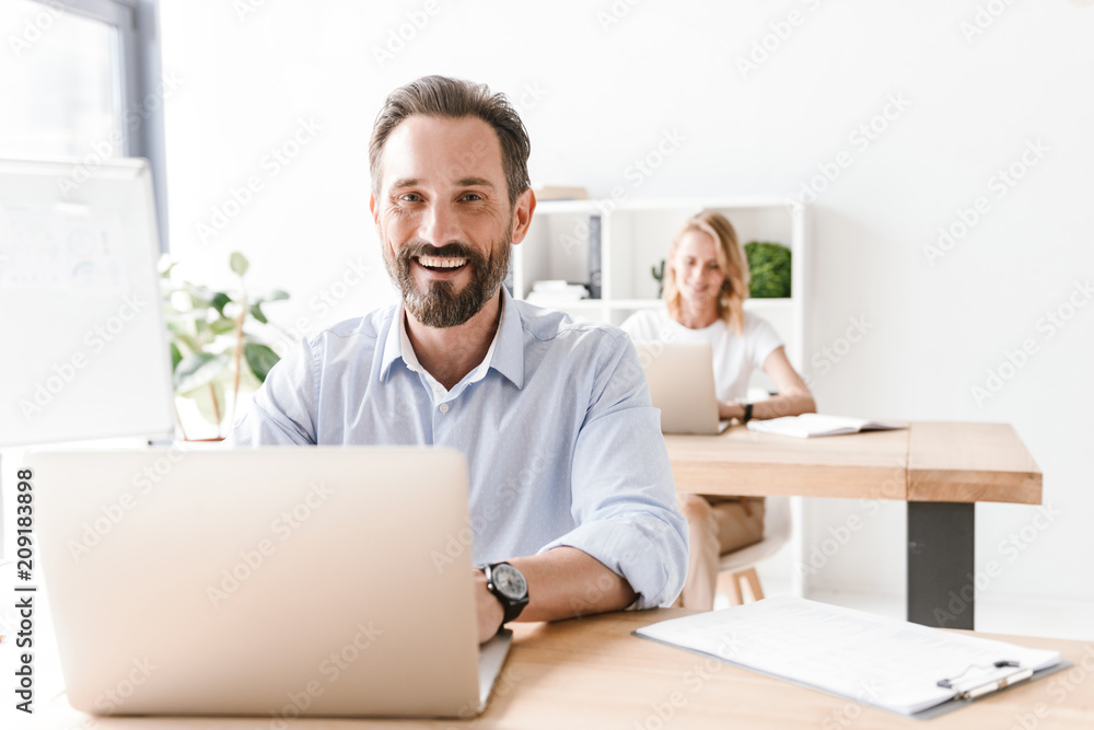 Laughing man manager working on laptop Laughing man manager working on laptop