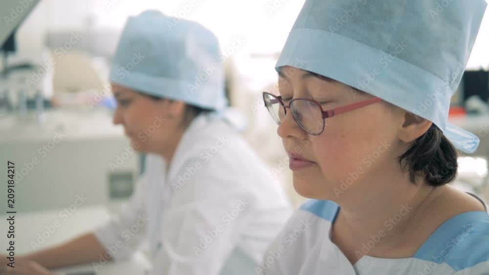 A nurse looks at a monitor, while working at a hospital. HD. A nurse looks at a monitor, while working at a hospital. HD.