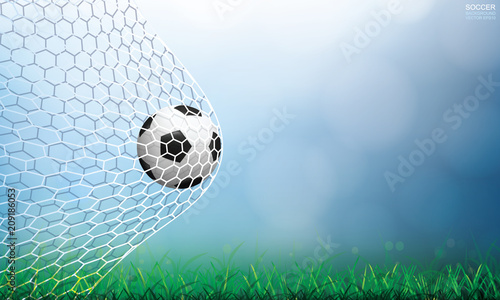 Soccer football ball in soccer goal and net with light blurred bokeh background and green grass field. Vector illustration.