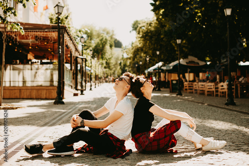 Photography Young couple sitting on street in a sunny day