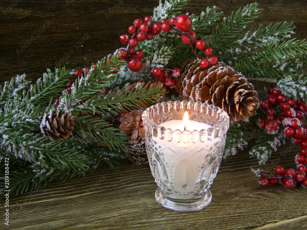 Christmas decorations and a candle on a wooden background