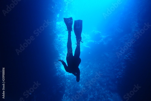 Silhouette of a diver in blue water while cave diving in Neiafu, Vavau, Tonga photo