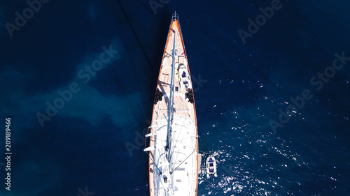 Aerial drone bird's eye view photo of wooden deck luxury sail boat docked in mediterreanean deep blue waters © aerial-drone