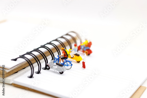 Miniature people parking on the book spine.