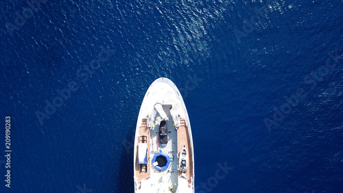 Aerial drone bird's eye view photo of luxury yacht with wooden deck docked in ocean deep blue waters