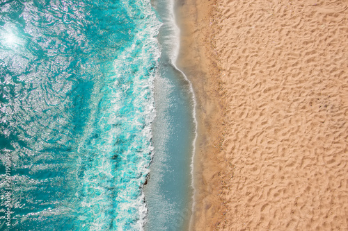 Coastline Beach Ocean waves with foam on the sand. Top view from drone.