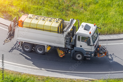 Street cleaning sweeper machines pumping water for washing asphalt road. photo