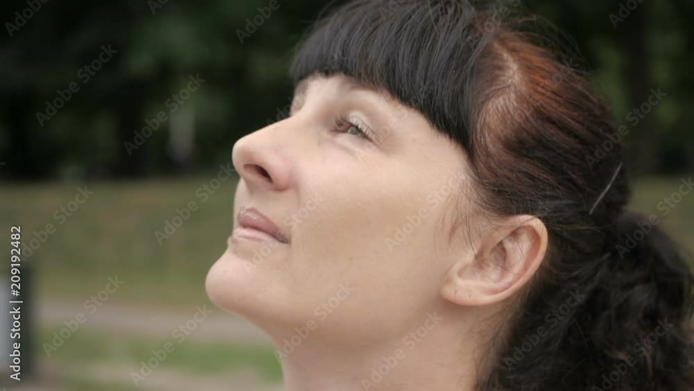 Closeup portrait of sensitive woman is looking up . Headshot of attractive girl with pretty face looking at the sky. City lifestyle Closeup portrait of sensitive woman is looking up . Headshot of attractive girl with pretty face looking at the sky. City lifestyle