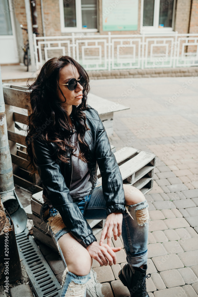 sværge erhvervsdrivende ozon Casual beauty. Close up fashion woman, vintage denim biker leather jacket,  rock n roll style, fit girl posing on the street, stylish outfit. On the  background of light yard. Stock Photo 