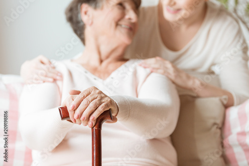 Close-up of elderly woman holding walking stick in the nursing house photo