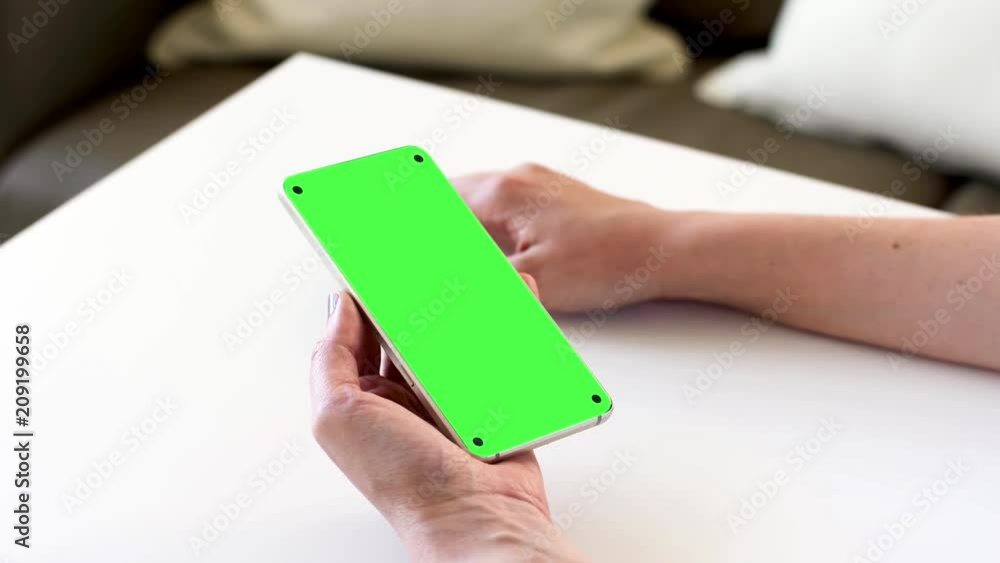 technology concept - female hands holding smartphone with blank green screen technology concept - female hands holding smartphone with blank green screen
