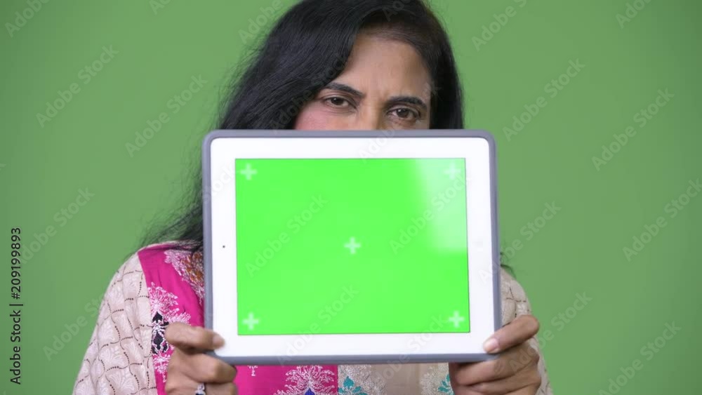 Mature beautiful Indian woman showing digital tablet Mature beautiful Indian woman showing digital tablet
