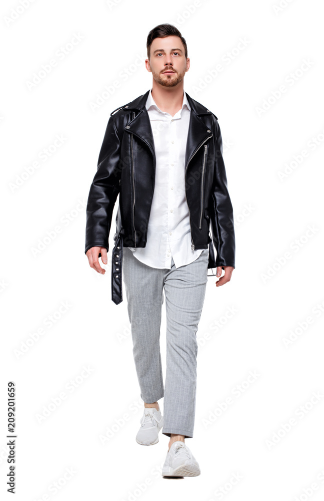 Front view of going handsome man in a leather jacket and trousers. Front view of going handsome man in a leather jacket and trousers.