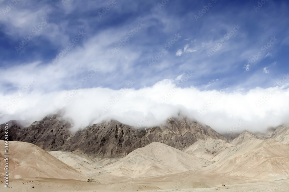 mountain range covered with thick clouds of a moving weather front in the alpine desert of the Tibetan Plateau (China) mountain range covered with thick clouds of a moving weather front in the alpine desert of the Tibetan Plateau (China)