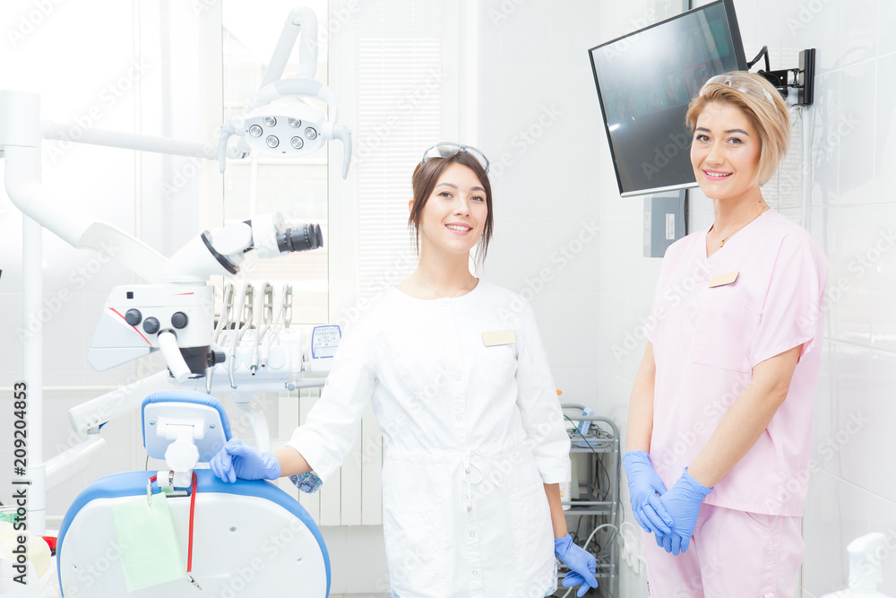 Fototapeta premium Two young girls-dentists in the treatment room.