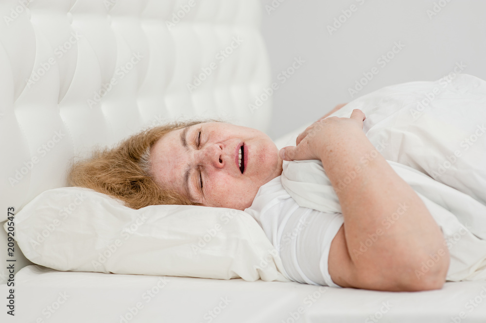 senior woman sleeping and snoring on the bed senior woman sleeping and snoring on the bed