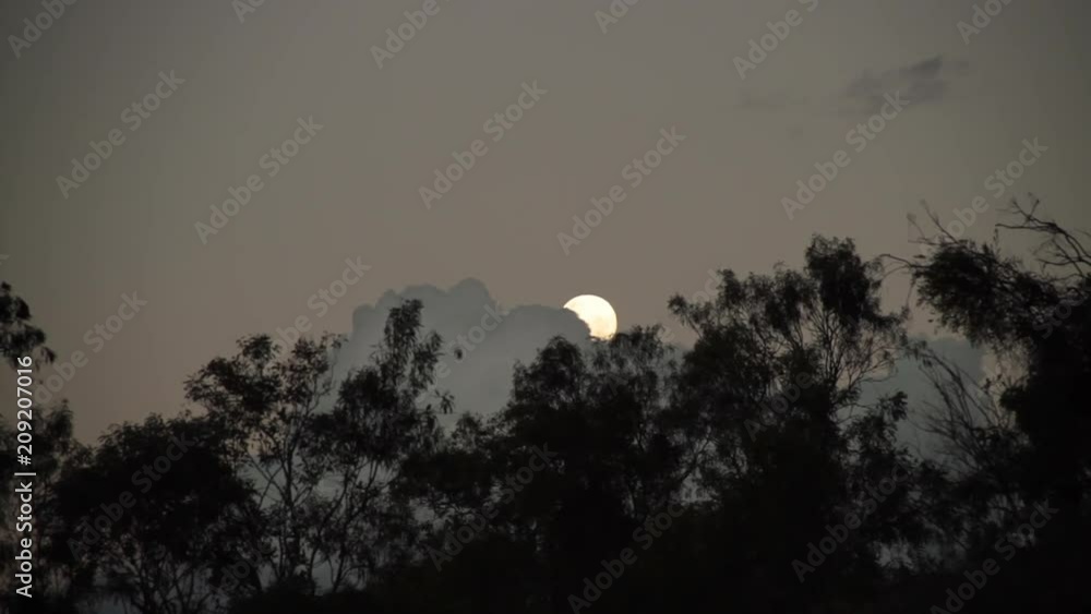 A long shot of the moon as the clouds try to cover it.