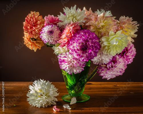 Fototapeta Naklejka Na Ścianę i Meble -  a lush arrangement of garden dahlias in an antique glass vase.