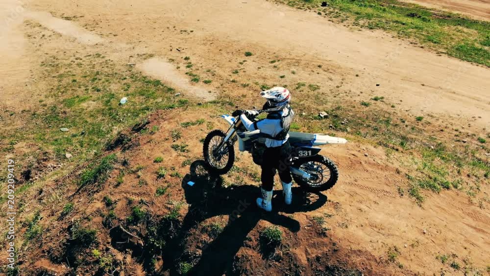 Professional biker with his autobike standing on a hill. Professional biker with his autobike standing on a hill.
