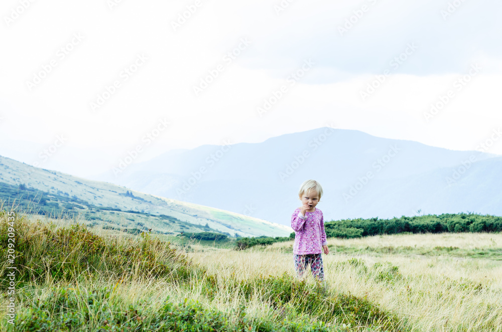 A happy child in trekking in the mountains. The child walks the hills.