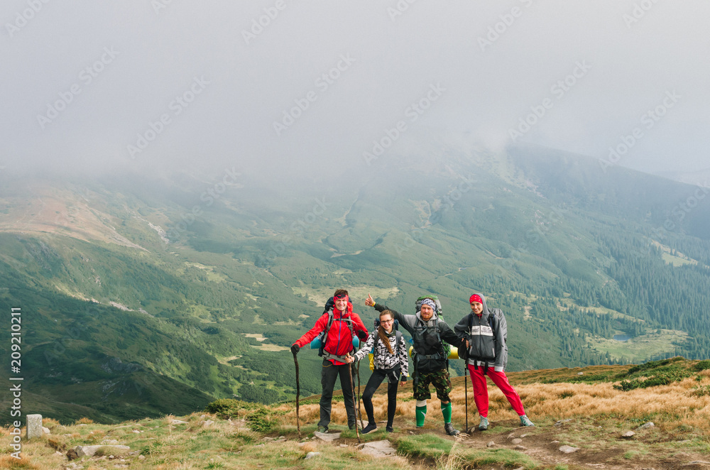 Hikers with backpacks in mountain and enjoying the view of valley