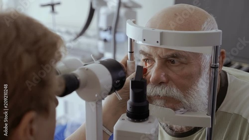 Doctor check eyesight of senior man with biomicroscope photo
