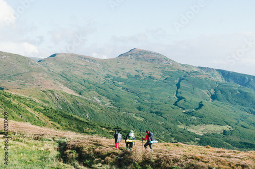 Hikers with backpacks in mountain and enjoying the view of valley