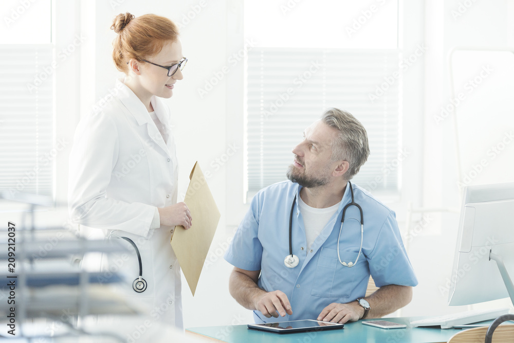 Fototapeta premium Doctor talking with assistant