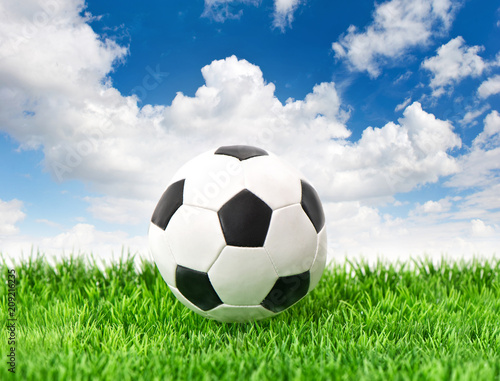 Soccer ball green grass blue sky background Football