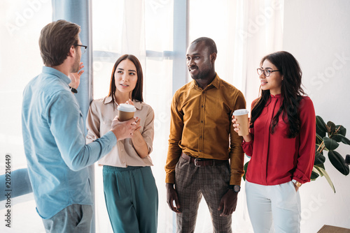 group of multicultural business people having conversation during coffee break in office