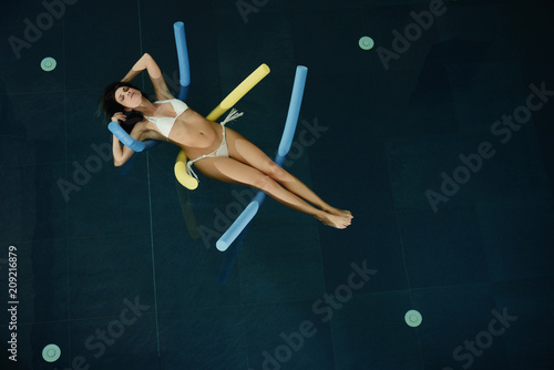 beautiful woman floating in the water in spa pool