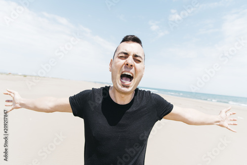 caucasian man screaming outdoors photo