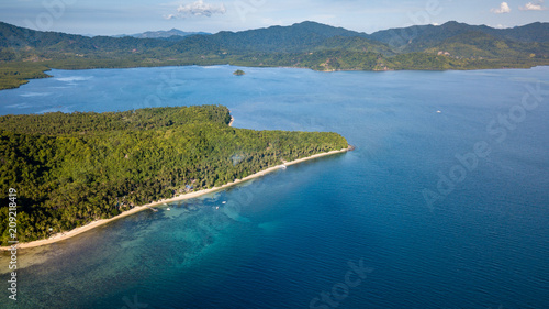 Aerial drone view of a beautiful tropical bay with reef, sandy beach and jungle scenery