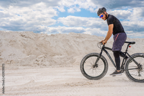 Training a bicyclist in a chalky quarry. A brutal man on a fat bike.  © Mikhail