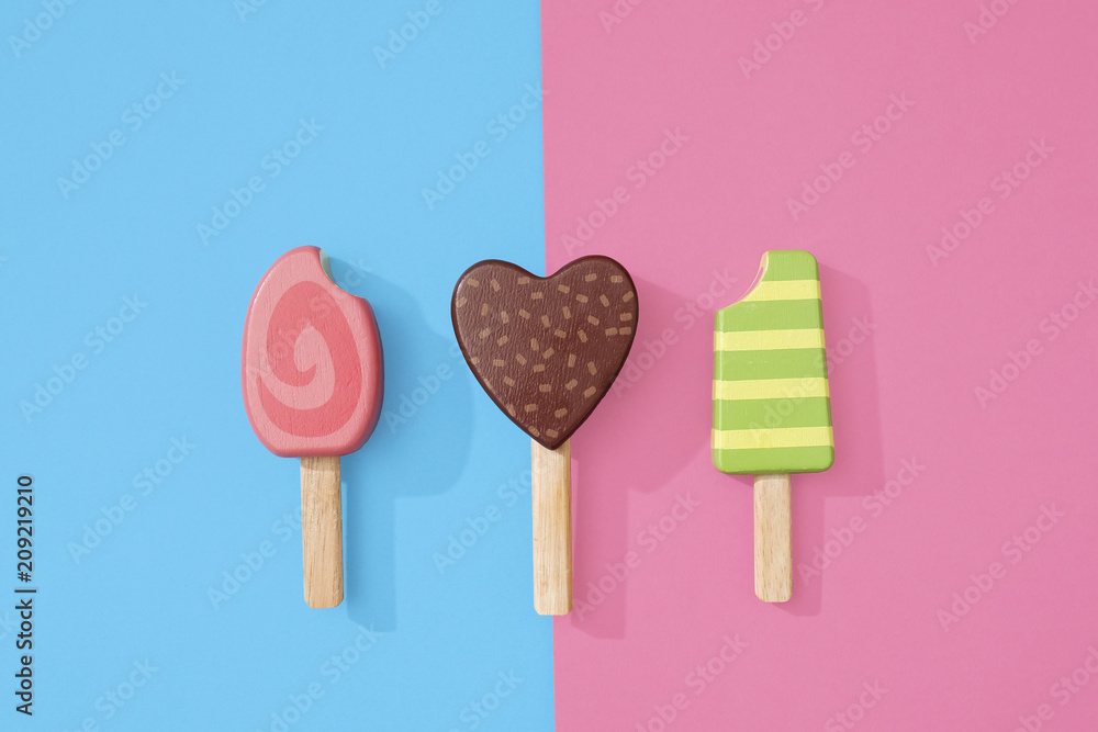 Ice cream popsicles lollipops on blue and pink pastel background for