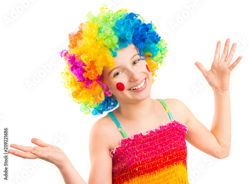 Little girl in funny clown wig with red spots on her cheeks isolated on white background
