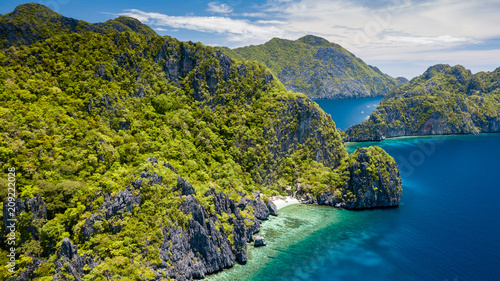 Aerial drone view of a beautiful tropical island with jagged cliffs and empty sandy beaches (El Nido, Palawan)