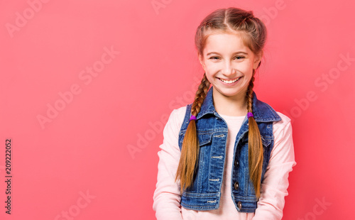 Fényképezés Smiling teen girl with two french braid in casual clothes posing over pink backg