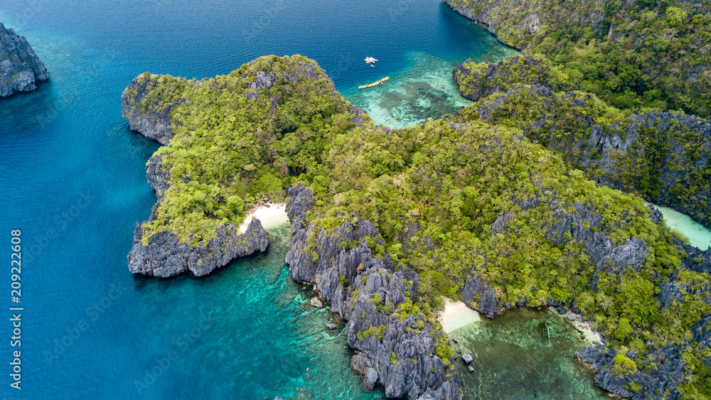 Aerial drone view of a spectacular tropical lagoon with small beaches and jagged cliffs