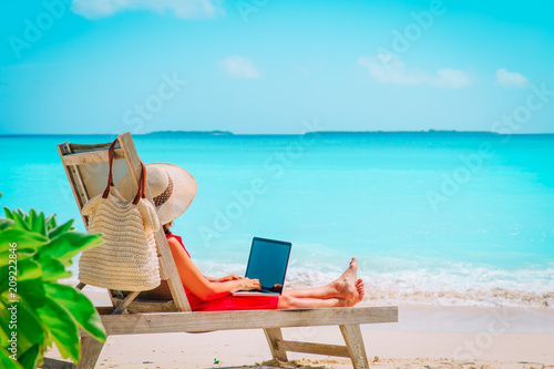 remote work concept -young woman with laptop on beach