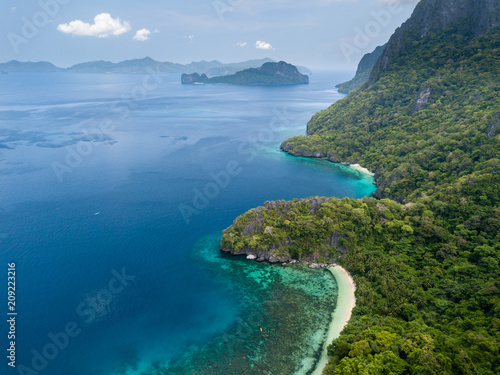 Aerial drone view of a tropical island, surrounding coral reefs, jungle and beaches