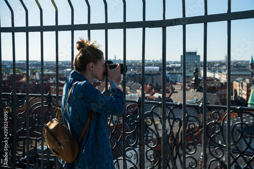 selective focus of young woman taking picture of copenhagen city  denmark