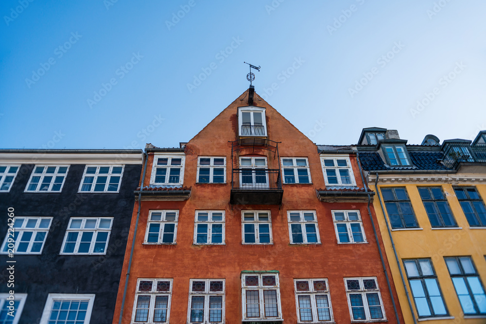 low angle view of beautiful colorful houses against blue sky, copenhagen, denmark