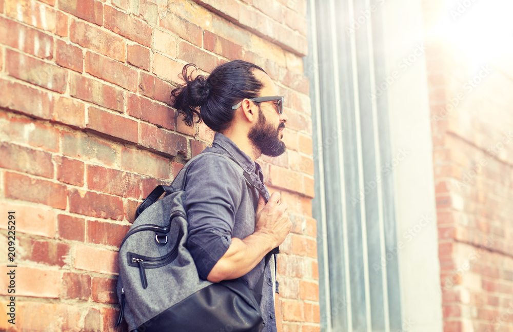 travel, tourism, lifestyle and people concept - man with backpack standing at city street wall travel, tourism, lifestyle and people concept - man with backpack standing at city street wall